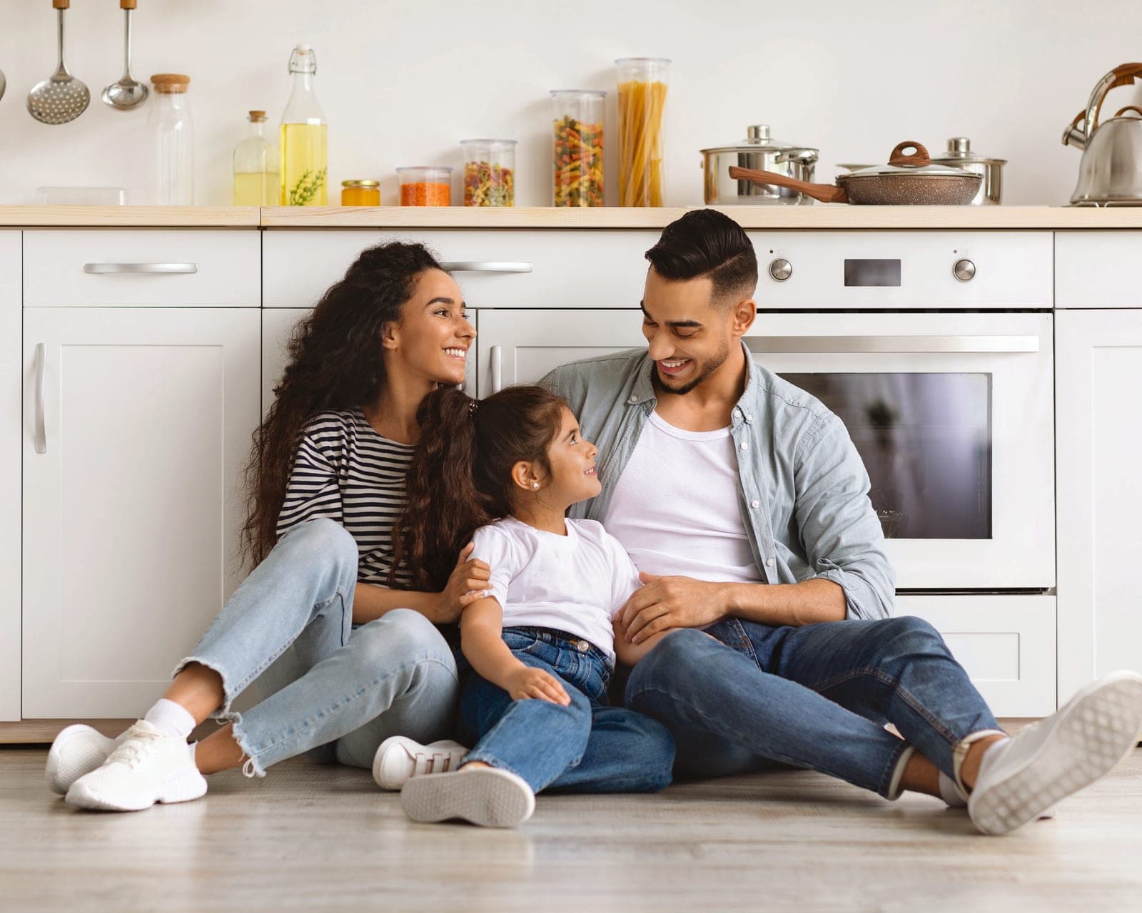 A family relaxing on the kitchen floor of a new home