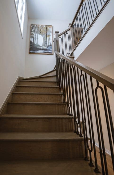 Stained oak staircase with metal pickets. Artist's concept.